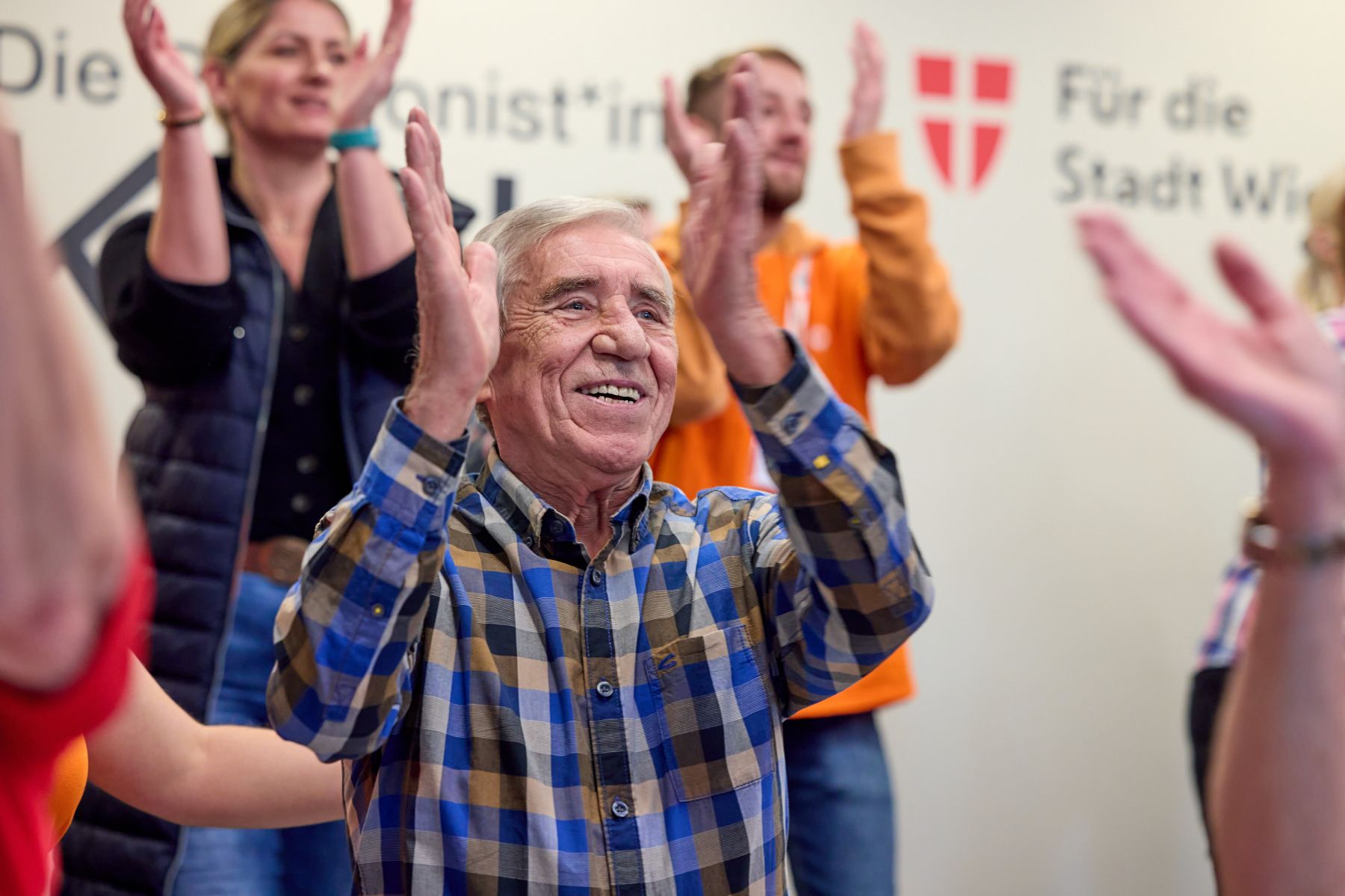 Personen klatschen und lachen.