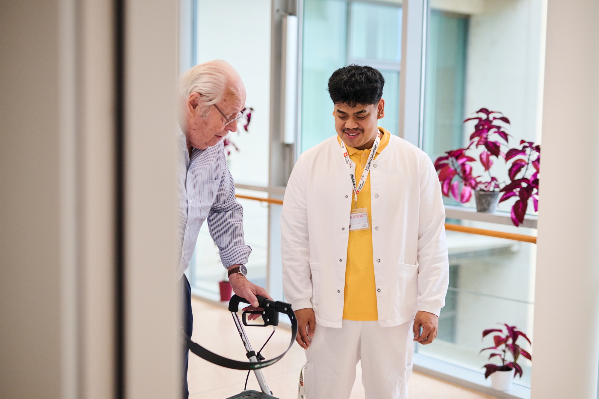 Ein älterer Mann mit Rollator und ein Zivildiener
