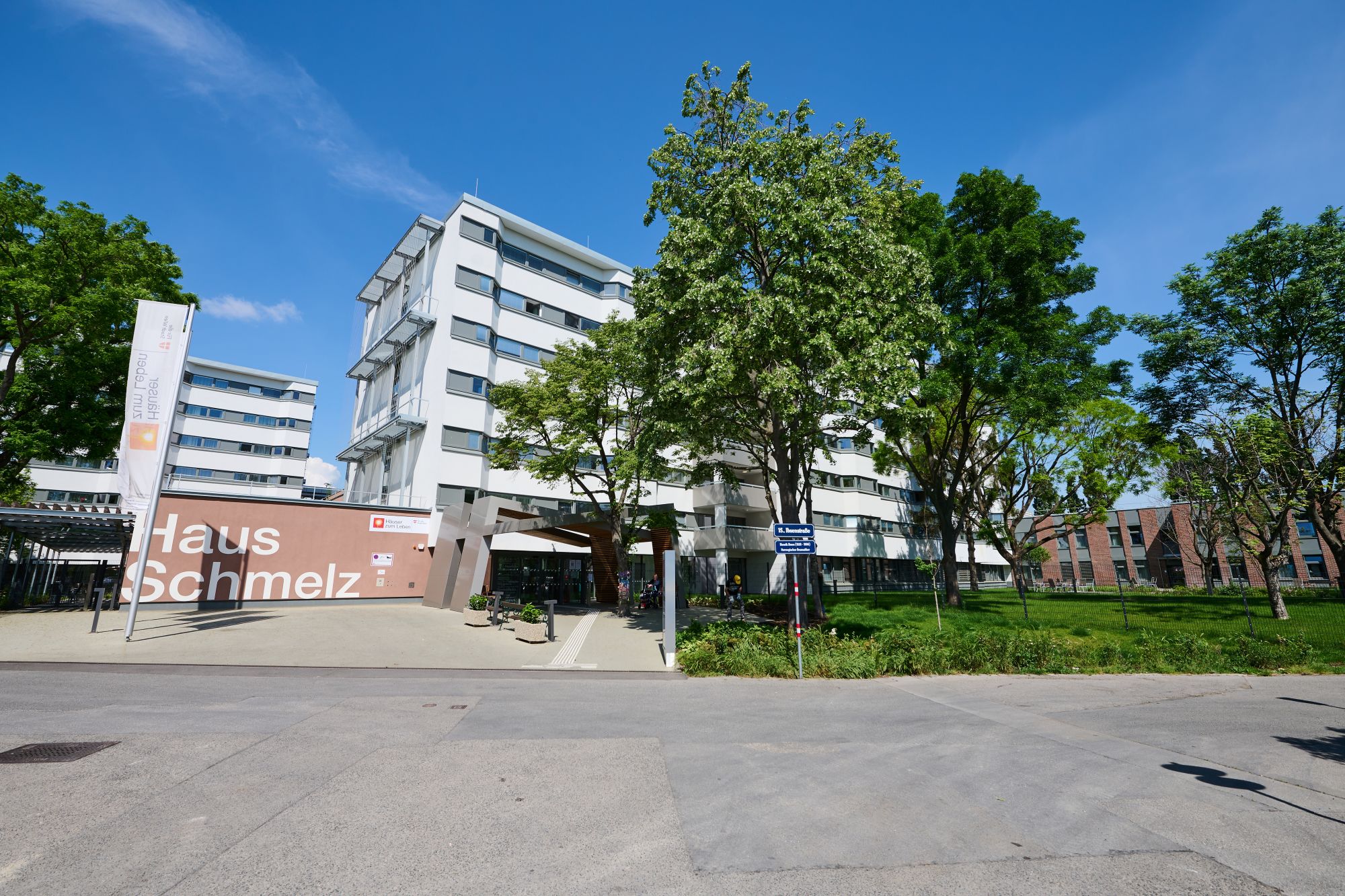 Pensionisten-Wohnhaus Schmelz, Gebäude mit Bäumen und Aufschrift "Haus Schmelz"